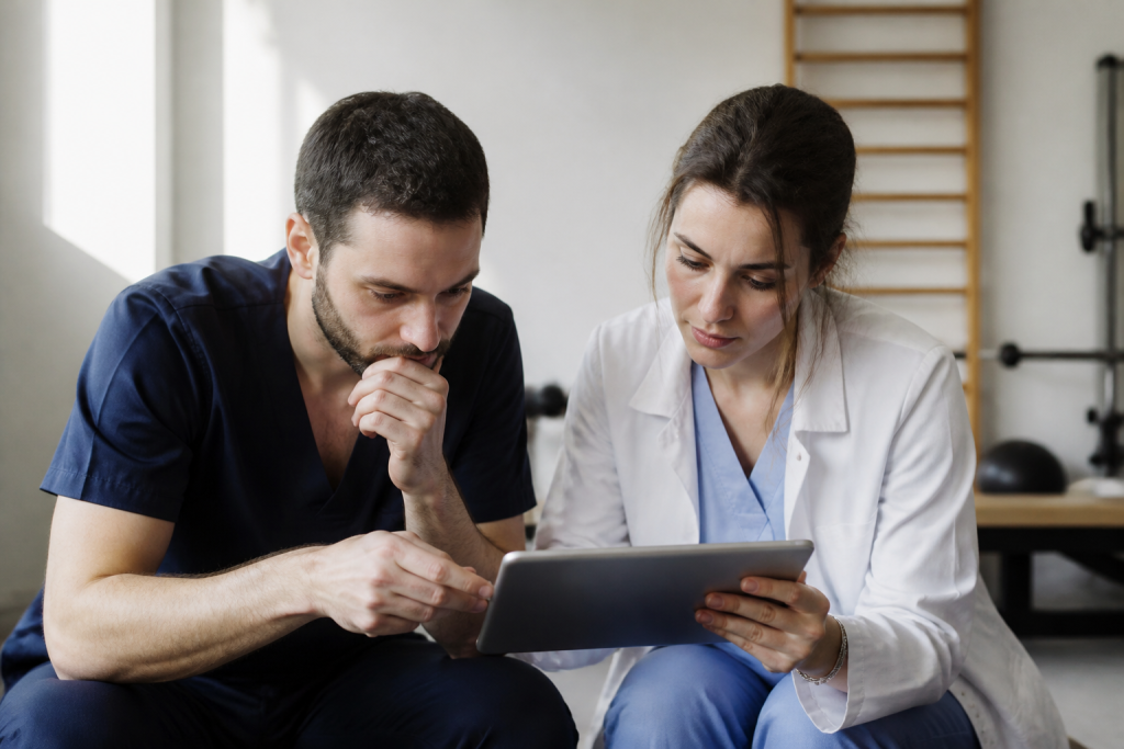 Medecin et kinesitherapeute observant une radiographie sur tablette